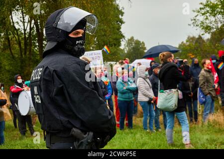 Eschede, 26. September 2020: Polizist mit Helm und Pistole in schwarzer Uniform steht vor den Demonstranten einer aga Stockfoto