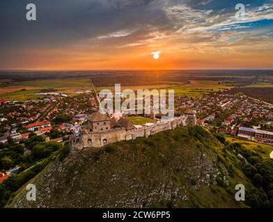 Sumeg, Ungarn - Luftaufnahme des berühmten Hohen Schlosses von Sumeg in Veszprem Grafschaft bei Sonnenuntergang mit bunten Wolken und dramatischen Farben des Sonnenuntergangs am Bac Stockfoto