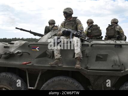 Flagge der Flagge von Arzakh und auch bekannt als Berg-Karabach Republik auf einem gepanzerten Personalträger und Soldaten mit Maschinengewehren. Collage. Stockfoto