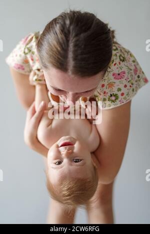 Mutter spielt mit Tochter und hält sie auf den Kopf Stockfoto