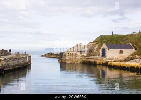 Der kleine Hafen von ballintoy an der Nord Küste von Antrim, Nordirland mit seinen alten Stein Bootshaus an einem Tag im Frühling Stockfoto