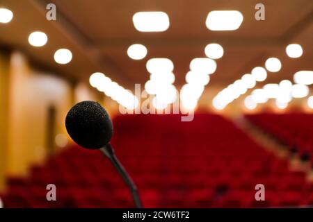 Nahaufnahme eines Mikrofons mit unscharfem Hintergrund und Bokeh-Lichtern des Auditoriums mit selektivem Fokus auf das Mikrofon. Stage mic Fear Concept-Bild Stockfoto