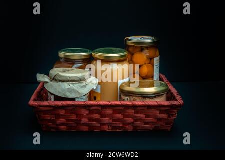 Geschenkkorb mit Gourmet-Produkten, Gläsern und Konserven von lokalen Produkten Stockfoto