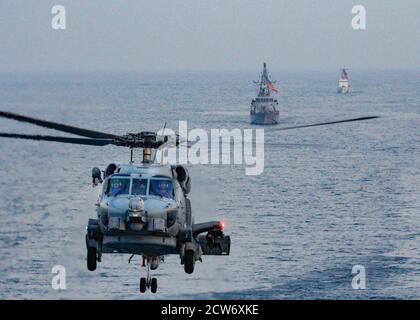 200924-N-PS962-0029 ARABIAN GULF (SEPT 24, 2020) EIN MH-60R Sea Hawk Hubschrauber, das Navy Küstenpatrouillenschiff USS Tempest (PC 2), Zentrum, Und das Küstenwache-Patrouillenboot USCGC Adak (WPB 1333) kommt während einer gemeinsamen Luftoperation zur Unterstützung der Seeoberflächenkriege (AOMSW) mit dem Lenkraketen-Zerstörer USS Winston S. Churchill (DDG 81), nicht abgebildet, im Arabischen Golf, Sept. 24, in Formation. Winston S. Churchill wird in der 5. Flotte Einsatzgebiet zur Unterstützung von Marineoperationen eingesetzt, um die maritime Stabilität und Sicherheit in der Zentralregion zu gewährleisten, die das Mittelmeer und P verbindet Stockfoto