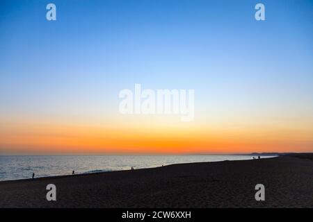 Sonnenuntergang und die Küste am Strand von West Bexington, einem Dorf im Südwesten von Dorset, England, liegt hinter Chesil Beach in der Nähe von Bridport Stockfoto