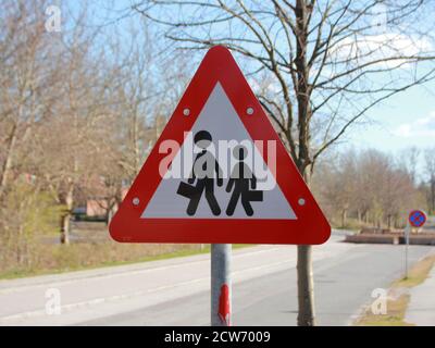 Ein dreieckiges Straßenschild, das den Fahrern aufzeigt, auf Schulkinder in der Gegend vorsichtig zu sein. Das Zeichen zeigt ein Dreieck mit einem roten Rand und zwei Stick Figur Stockfoto