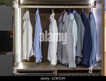 Business Shirts und Anzüge an Kleiderbügeln im Kleiderschrank Stockfoto