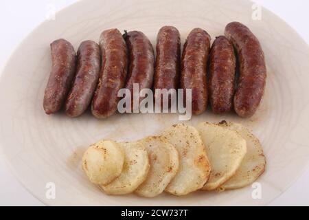 Gekochte Schweinswürste mit Kartoffelseite Stockfoto