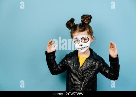 Nettes kleines Mädchen trägt erschreckende Make-up gestikulieren mit Händen zeigt große und große Zeichen, Maßnahme Symbol, isoliert auf blauem Studio-Hintergrund. Fac Stockfoto