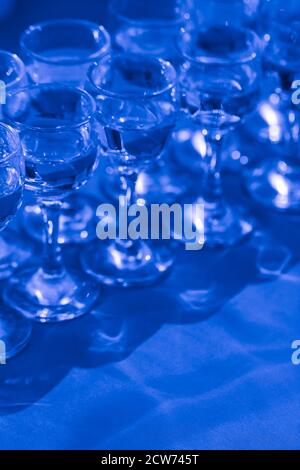 Elegante Wassergläser, Nahaufnahme, Draufsicht, in klassischem Blau getönt. Stockfoto