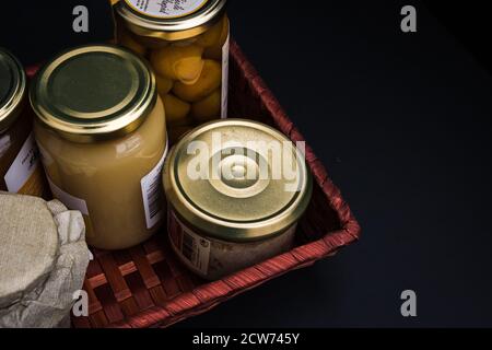 Geschenkkorb mit Gourmet-Produkten, Gläsern und Konserven von lokalen Produkten Stockfoto