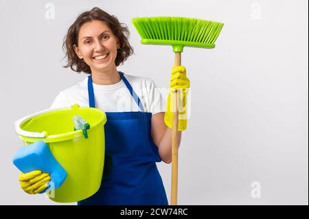 Frau reinigt das Haus. Die Frau hält einen Mopp und einen Eimer und Handschuhe und einen Reinigungsschwamm. Raumreinigungskonzept Stockfoto