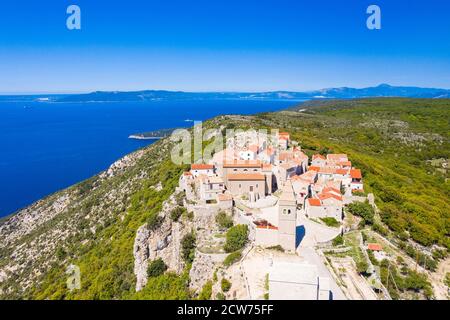 Luftaufnahme der kleinen historischen Stadt Lubenice auf der hohen Klippe, Insel Cres in Kroatien, Adria im Hintergrund Stockfoto