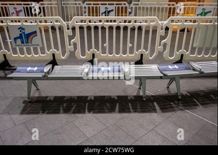 LONDON - 14. SEPTEMBER 2020: Eine Reihe A Sitze mit Social Distancing Zeichen und Menschenmengen-Kontrolle Barrieren im Hintergrund bei King's Cross Bahnhof d Stockfoto