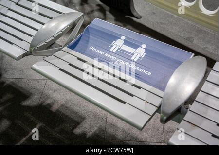 LONDON - 14. SEPTEMBER 2020: Warnschild zur sozialen Distanzierung auf einem Sitz am Bahnhof King's Cross während der Pandemie von Covid 19 Stockfoto