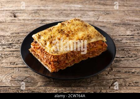 Stück Fleischlasagne auf schwarzem Teller Stockfoto