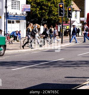 London, Großbritannien, September 28 2020, Gruppe junger Menschen, die Straße an der Ampel überqueren COVID-19 Stockfoto