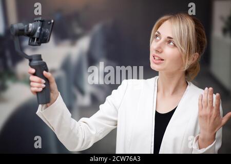 Junge Geschäftsfrau Aufnahme Video Blog auf Smartphone im Büro des Unternehmens Stockfoto