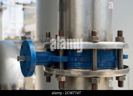 Industriegebiet. Industrieanlagen, Rohre und moderne Technik. Metallobjekte in einer Fabrik. Nahaufnahme von Schrauben und Rohren der Technologielinie Stockfoto