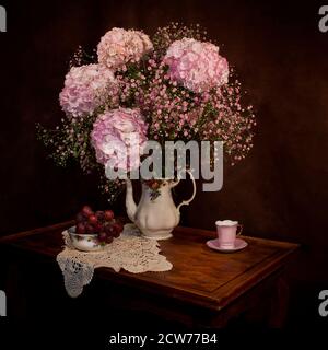 Stillleben Studie mit rosa Hortensien und Trauben Stockfoto