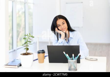 Ziemlich erfolgreiche schwarze Geschäftsfrau posiert im modernen Büro. Selbstbewusste Frau, Frau im Geschäft Stockfoto