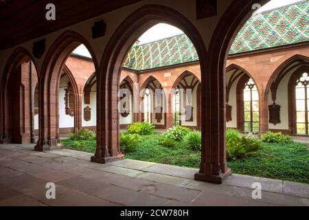 Grünpflanzen im Innenhof des Basler Doms. Kreuzgang mit Torbogen und Innengarten. Schweiz. Stockfoto