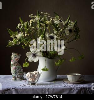 Stillleben weiße Blume Studie mit chinesischen Katze und meringues Und weiße Blumen Stockfoto