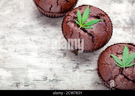 Schokolade Cupcake Muffins mit Cannabis Blätter Unkraut cbd. Medizinische Marihuana Hanf Drogen in Lebensmitteln Dessert. Kochen Backen Unkraut Muffins mit Marihuana auf Stockfoto