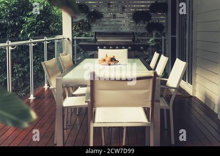 Tisch und Stühle auf der Veranda in einem Landhaus im Regenwald. Großer Esstisch und Grill auf dem Balkon Stockfoto
