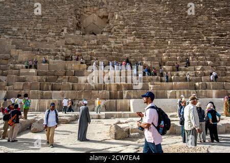 Besucher des Gizeh-Plateaus in Kairo in Ägypten klettern über die riesigen Steinblöcke der Pyramide von Khufu. Stockfoto