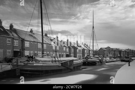 Vintage Lastkähne günstig entlang der gefrorenen Beck (Kanal) und im Schnee durch die Stadt Häuser in Beverley, Yorkshire, UK flankiert. Stockfoto