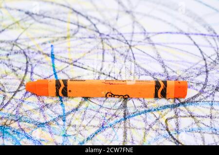 POZNAN, POLEN - 14. Mai 2016: Oranger Crayon-Zeichnungsstock auf weißem Papier mit bunten Zeichnungen Stockfoto