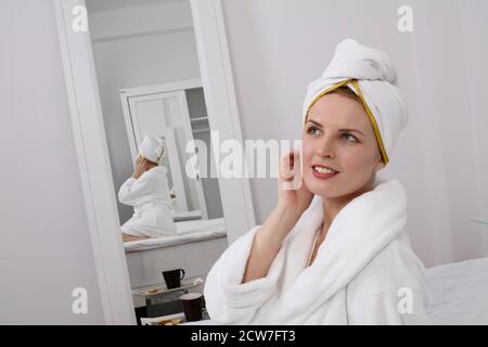 Junge Frau im Bademantel denken Stockfoto