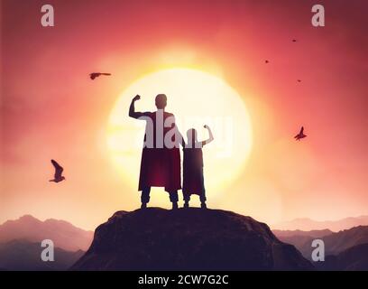 Glückliche liebevolle Familie. Vater und seine Tochter spielen draußen. Papa und sein Mädchen in einem Superhelden-Kostüme. Stockfoto