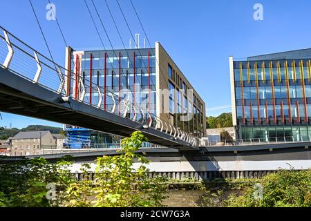 Pontypridd, Wales - September 2020: Menschen, die über die Fußgängerbrücke über den Fluss Taff zu Büros in der neuen Taff Vale Entwicklung in Pontypridd gehen Stockfoto