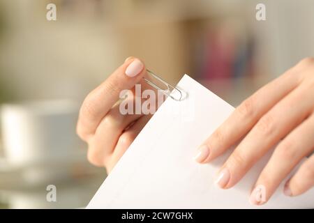 Nahaufnahme einer Frau Hände setzen eine Büroklammer Auf einem Blatt zu Hause Stockfoto