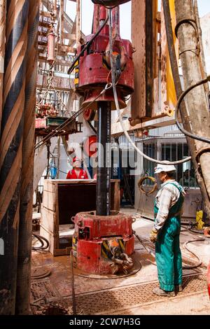 Öllagerstätte Zhaikmunai. Zwei Arbeiter auf einer Ölplattform mit Bohrrohren und Ausrüstung. Öllagerstätte Zhaik-Munai, Kasachstan. Stockfoto