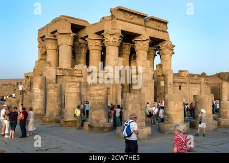 Am späten Nachmittag drängen sich Touristen um die Ruinen des Kom Ombo Tempels auf dem Nil in Ägypten. Der Tempel wurde im 2. Jahrhundert v. Chr. erbaut. Stockfoto