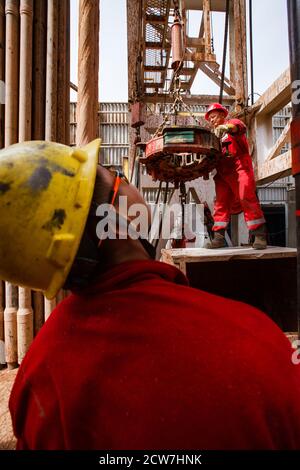 Öllagerstätte Zhaikmunai. Ölbohranlage. Arbeiter, die elektrische Drahtreifen zum Bohren von Rohren verwenden. Öllagerstätte Zhaik-Munai, Kasachstan Stockfoto