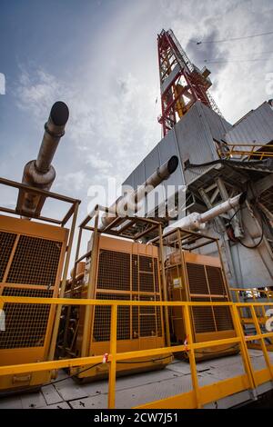 Zhaik-Munai Öllagerstätte, Kasachstan. Diesel-Motor-Station und Generatoren von Strom. Mobiles Kraftwerk. Ölstand im Hintergrund. Stockfoto