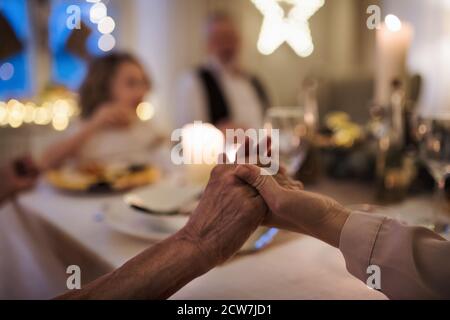Nahaufnahme der Hände, die an Weihnachten am Tisch zusammenhalten. Stockfoto