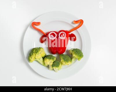 Lustige Teller mit Symbol der 2021 Stierkkuh aus Gemüse: Paprika, Brokkoli, Tomaten und Zwiebeln. Frühstücksidee für Kinder. Vegan oder vegetarisch fo Stockfoto