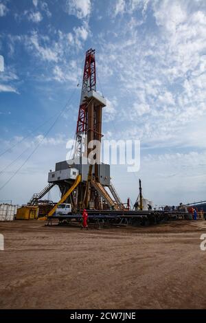 Zhaik-Munai Öllagerstätte, Kasachstan. Ölbohranlage und Ölarbeiter in rot Arbeit tragen und Helm. Arbeitet auf Ölablagerung. Stockfoto