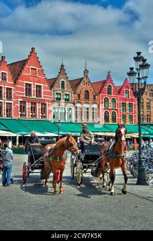 Kutschen auf dem Marktplatz, bekannt als Markt, farbige Häuser und bezaubernde Straßencafés in Brügge, UNESCO-Weltkulturerbe, Belgien Foto © Fa Stockfoto