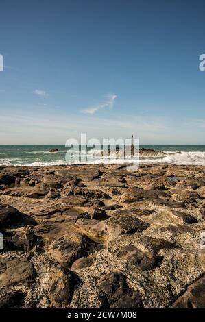 Portraitbild des Barrel Rock am Ende des Bude Wellenbrechers mit atlantischen Wellen, die gegen die Felsen krachen. Stockfoto