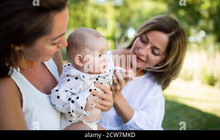 Frau mit Tochter und Baby Enkelin Ruhe im Freien im Hinterhof. Stockfoto