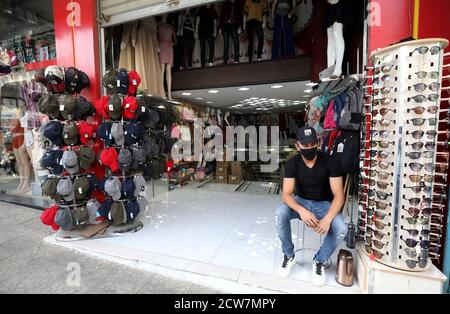 Nablus. September 2020. Ein palästinensischer Verkäufer mit Gesichtsmaske sitzt am 28. September 2020 vor seinem Geschäft auf einem Markt in der Stadt Nablus im Westjordanland. Palästina verzeichnete am Sonntag 620 neue COVID-19 Fälle, was die Gesamtzahl der Infektionen in den palästinensischen Gebieten auf 49,192 erhöht. Quelle: Ayman Nobani/Xinhua/Alamy Live News Stockfoto