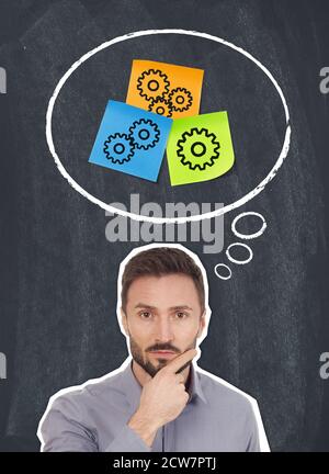 Haftnotizen mit Zahnradzeichnungen auf Tafel und Businessman Thinking Stockfoto