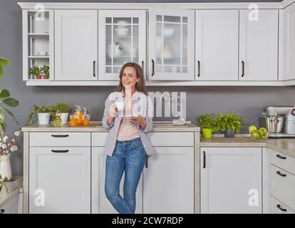 Junge Frau trinkt Kaffee in der Küche Stockfoto