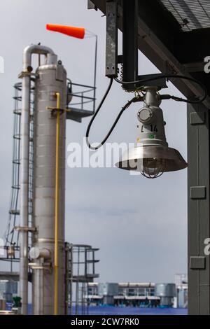 Ölraffinerie-Werk. Sicherheitstechnologien und Dinge. Explosionsgeschützte Lampe. Wetterfahne auf Destillationsturm. Zhaik-Munai Öllagerstätte, Kasachstan. Stockfoto